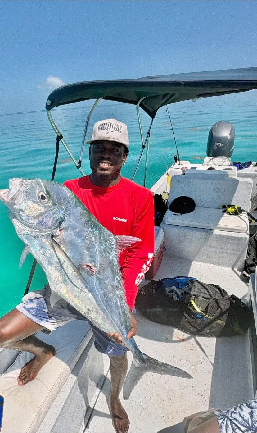 Captain Jamar holding a big jack on his boat