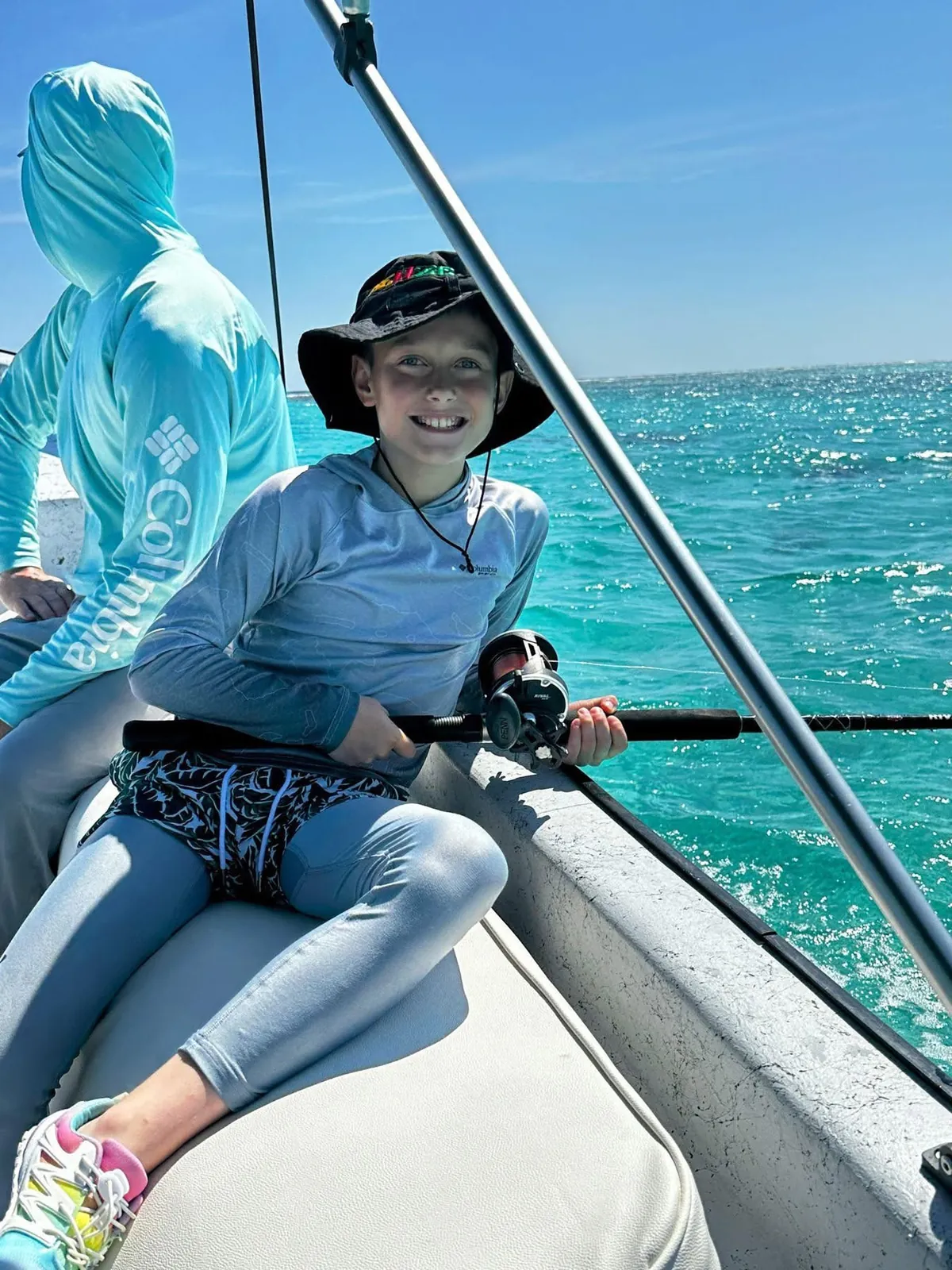 Young angler with a rod on the boat